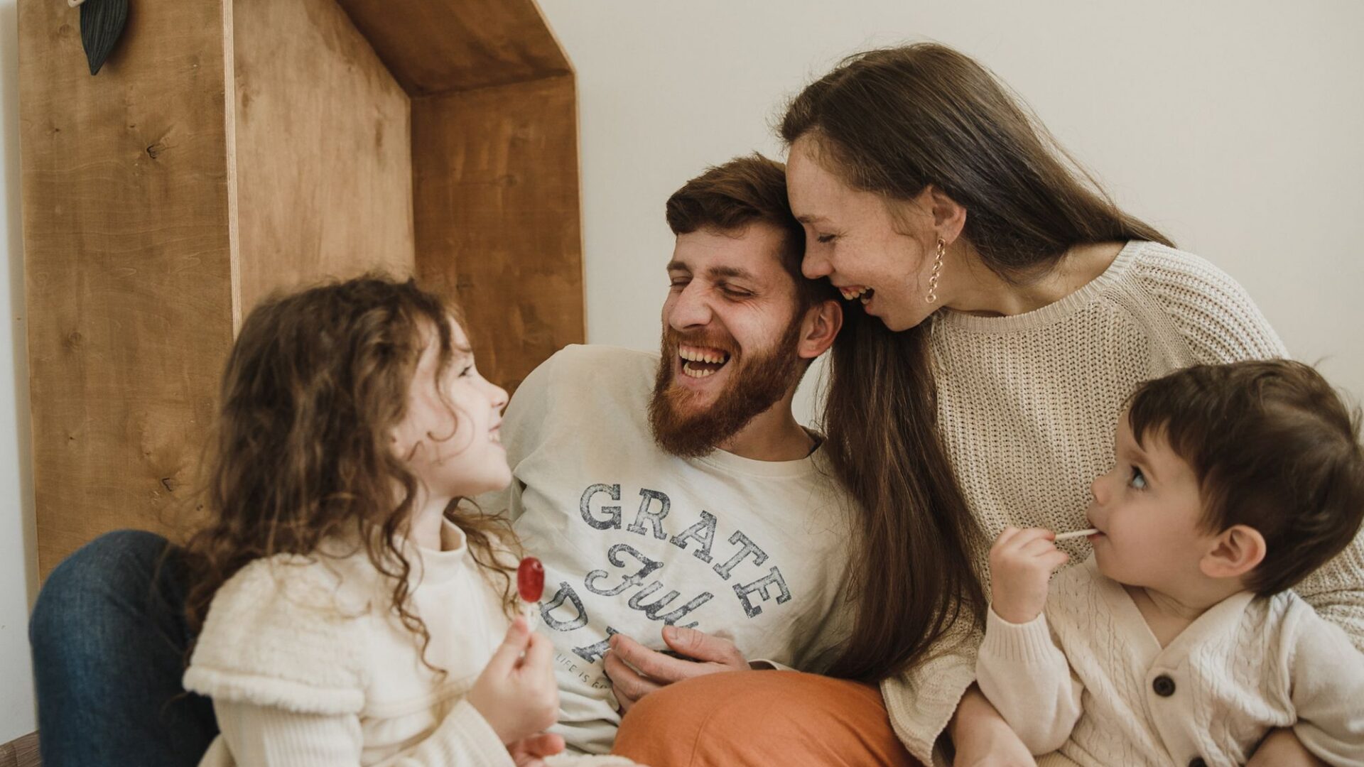 הורים וילדים צוחקים יחד בבית